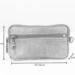 May include: A brown leather zippered pouch with a YKK zipper pull. The pouch measures 5.5 inches wide by 3 inches tall and 0.75 inches deep.