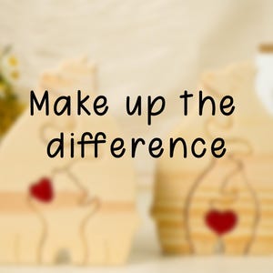 May include: Two wooden figurines with hearts in the center. The figurines are standing on a light wood surface. The text "Make up the difference" is written in black on a white background.