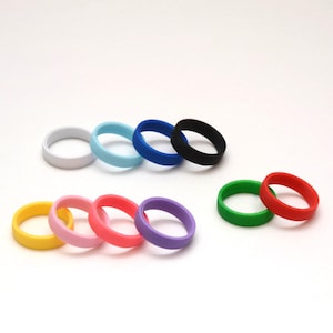 May include: Assortment of colorful silicone rings in various colors, including white, light blue, blue, black, green, red, pink, and purple.