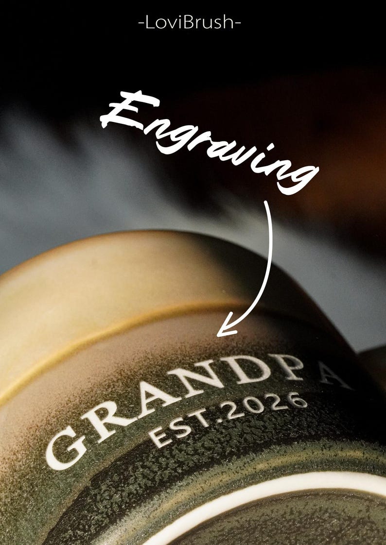 May include: Close-up of a ceramic mug with the word "GRANDPA" and "EST. 2026" in white lettering. The mug has a gradient color scheme, transitioning from a light tan to a dark green. The word "Engraving" is written above the mug.