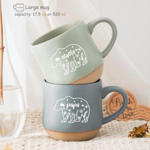 May include: Two ceramic mugs with bear designs. The green mug says "mama" and the grey mug says "papa". Both mugs have a brown rim and a capacity of 520 ml.