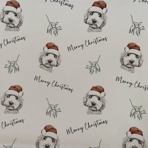 May include: Wrapping paper featuring a repeating pattern of a dog wearing a Santa hat, sprigs of mistletoe, and the words "Merry Christmas" in black script. The dog has a fluffy white coat and a brown hat.