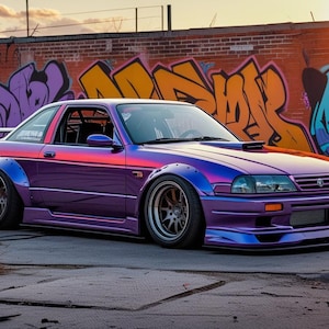 May include: A modified purple coupe with a wide body kit and custom wheels is parked on concrete. The car features a rear wing and a bonnet scoop. A brick wall with colourful graffiti art forms the backdrop.