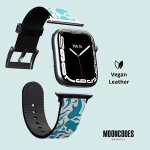 May include: An Apple Watch with a black strap and a patterned vegan leather band featuring blue whale shark illustrations on a light grey background. The watch face displays "TUE 14". The text "Vegan Leather" and "MOONCODES HOUSTON, TX" are also visible.