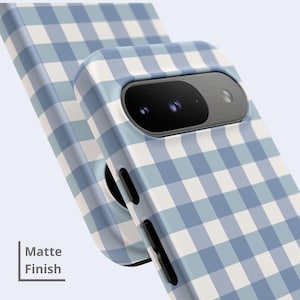 May include: A phone case with a light blue and white gingham check pattern and a matte finish. The case features a cutout for a dual-lens camera system and black side buttons. The text "Matte Finish" is visible in the lower left corner.