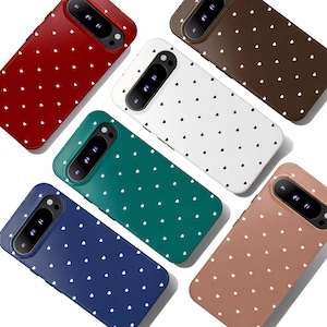Puede incluir: Una colección de fundas para teléfonos en varios colores, incluyendo rojo, marrón, blanco, verde, azul y beige. Cada funda presenta un patrón repetido de pequeños corazones blancos. Las fundas están diseñadas para un modelo de teléfono específico.