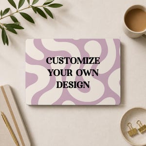 May include: A rectangular sign featuring a wavy, abstract pattern in shades of light purple and cream. The text "CUSTOMIZE YOUR OWN DESIGN" is printed in bold, black, sans-serif capital letters across the center of the surface.