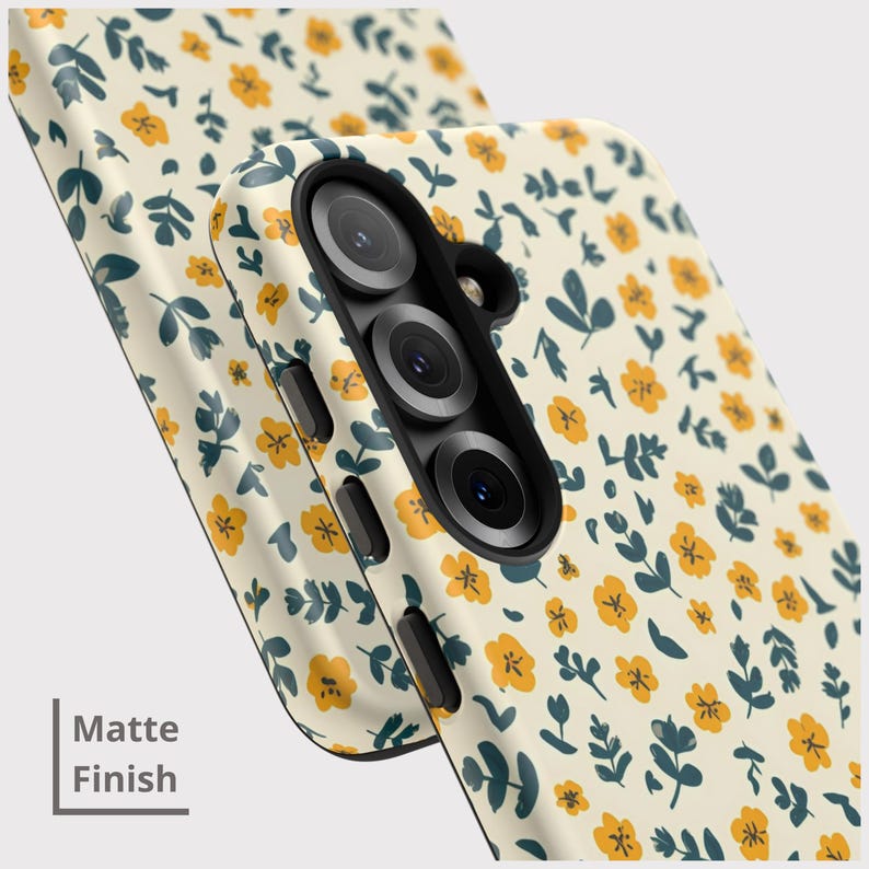 May include: A phone case with a matte finish, featuring a repeating pattern of small yellow flowers and dark teal leaves on a cream background. The case has a black camera module and side buttons. The text "Matte Finish" is visible.
