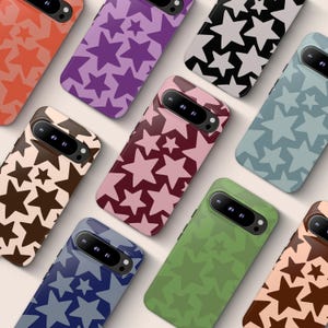 May include: A selection of mobile phone cases with star designs in various colours. The cases display patterns of stars in shades of red, purple, black, brown, pink, blue, and green. Each case provides a stylish and protective accessory.