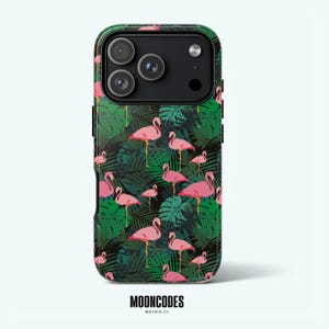 Puede incluir: Una funda de teléfono con un diseño tropical de flamencos rosas y hojas de palmera verdes sobre un fondo negro. La funda tiene un acabado brillante y la marca "MOONCODES" está impresa en la parte inferior.