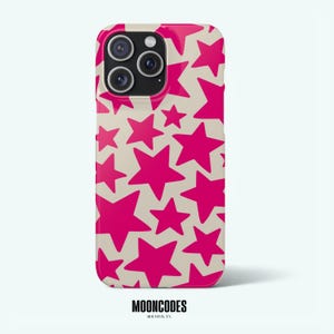 Puede incluir: Funda de teléfono con un patrón repetido de estrellas rosa brillante sobre un fondo beige. La funda tiene un acabado brillante y presenta un módulo de cámara con tres lentes. La marca "MOONCODES" está impresa en la parte inferior.
