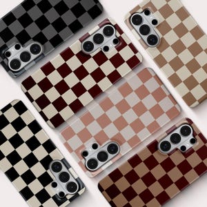 Puede incluir: Una colección de fundas para teléfonos con un patrón de cuadros en varios colores, incluyendo negro, gris, marrón y rosa. Cada funda tiene un recorte para la cámara y un acabado liso y brillante. Las fundas están dispuestas en un diseño superpuesto.