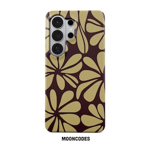 Puede incluir: Funda de teléfono con un estampado floral en tonos dorados y marrones. La funda tiene un recorte para la cámara y el texto "MOONCODES" en la parte inferior. El diseño presenta formas de flores estilizadas.