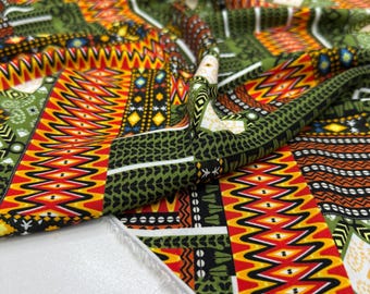 May include: Close-up of a vibrant fabric with a patchwork design. The fabric features a mix of geometric patterns in shades of green, orange, red, and yellow. The design includes zigzags, diamonds, and other shapes, creating a bold and colorful textile.
