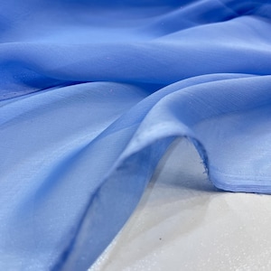 May include: A close-up of a light blue sheer fabric. The fabric is soft and flowing, with a subtle sheen.