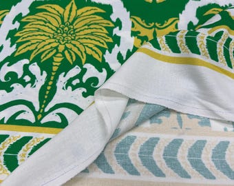 Könnte beinhalten: Weißer Stoff mit einem sich wiederholenden Muster aus grünen und gelben Palmen und floralen Designs. Der Stoff hat auch einen Rand mit einem gelben Streifen und einem Muster aus türkis- und beigefarbenen Pfeilen.