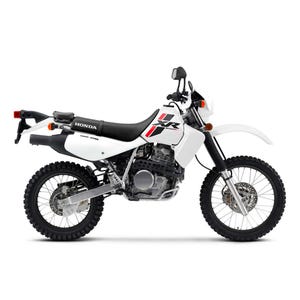 May include: White and black Honda XR motorcycle with black tires and a black seat. The motorcycle has red and black accents and the Honda logo is visible. The motorcycle is designed for off-road use.