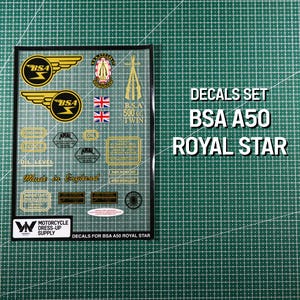 Puede incluir: Un juego de calcomanías BSA A50 Royal Star. Las calcomanías son doradas y negras, con texto que dice "BSA", "Made in England" y "Oil Level". El juego incluye varios logotipos y emblemas, incluida la bandera de la Union Jack. Sobre un fondo de cuadrícula verde.