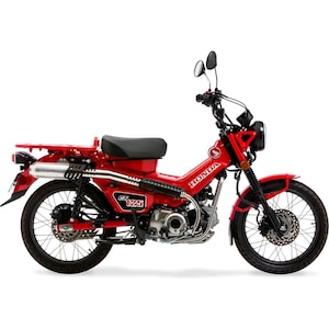 May include: A red Honda CT125 motorcycle with black tyres and a black seat. The motorcycle has a luggage rack, a headlight, and a silver exhaust pipe. The Honda logo is visible on the side.