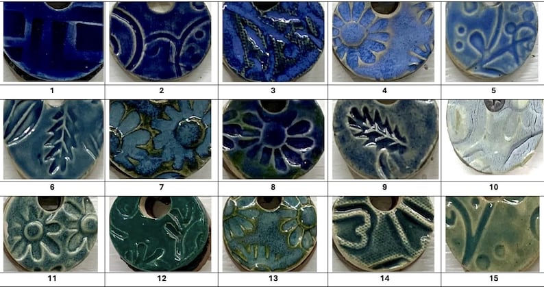 May include: A collection of fifteen ceramic pendants in various shades of blue and green. Each pendant features a unique embossed design, including floral, geometric, and abstract patterns. The pendants have a hole at the top for stringing.