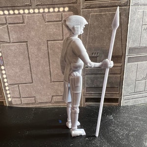 K&ouml;nnte beinhalten: Eine wei&szlig;e Plastikfigur einer Person, die eine Lanze h&auml;lt. Die Figur tr&auml;gt einen Helm und hat ein detailliertes Design. Die Lanze ist lang und d&uuml;nn, mit einer scharfen Spitze.