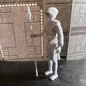 K&ouml;nnte beinhalten: Eine wei&szlig;e Plastik-Actionfigur eines Star Wars-Charakters, der eine Lanze h&auml;lt. Die Figur tr&auml;gt einen Helm und hat ein detailliertes Design.