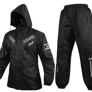 Op de afbeelding: Zwart waterdicht regenpak met een jas met capuchon en bijpassende broek. De jas heeft reflecterende strepen en de tekst "BYKR". De broek heeft ook reflecterende strepen en de tekst "BYKR".
