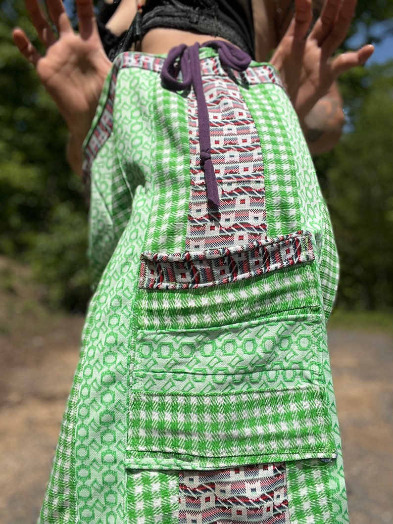 May include: Green and white checkered skirt with a colorful patterned panel and a purple drawstring tie.