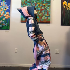 May include: A hooded jacket and matching pants set constructed from a patchwork of dark blue denim, solid light pink fabric, and a floral print fabric with thin stripes. The jacket features a hood, while the pants have a high-waisted design.
