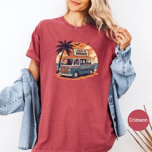 May include: Crimson-colored t-shirt featuring a Halloween-themed graphic. The design includes a vintage van with a pumpkin face, palm trees, and the text "I Scream for Summerween." The shirt has short sleeves and a relaxed fit.
