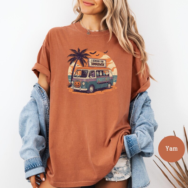 May include: A terracotta-colored t-shirt featuring a graphic of a van with ghosts, a pumpkin, and palm trees. The van has the text "I Scream for Summerween" on a sign. The design is set against a sunset backdrop with bats.