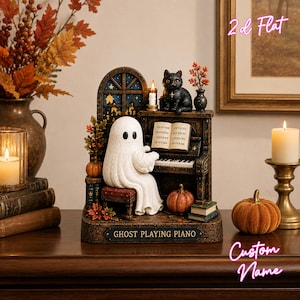 May include: A decorative figurine featuring a white ghost sitting on a bench playing a brown piano. A black cat sits on top of the piano next to a lit candle. The base has a plaque that reads GHOST PLAYING PIANO. Includes pumpkins and books.