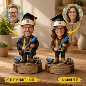 Puede incluir: Dos figuras de ingeniero, cada una con birrete y casco, sosteniendo un plano azul. Las figuras están sobre una base de madera con el texto "Trust me, I'm an Engineer Degree: Constructed Class of 2026".