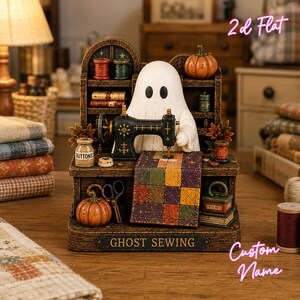 May include: A decorative figurine featuring a white ghost sitting at a black sewing machine with a colorful patchwork quilt. The base is labeled GHOST SEWING and includes miniature accessories like pumpkins, spools of thread, scissors, and books on shelves.