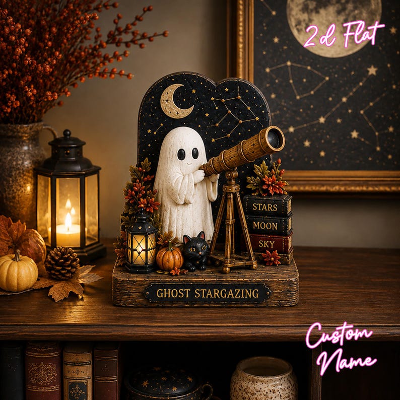May include: A decorative tabletop display featuring a white ghost looking through a brown telescope, a black cat, a small lantern, and pumpkins. The base is labeled GHOST STARGAZING, and a stack of books is marked STARS, MOON, and SKY on the spines.