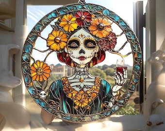 Può includere: Vetrata raffigurante una figura del Día de los Muertos. Il design circolare presenta uno scheletro femminile adornato di fiori e con in mano una candela. L'opera utilizza colori vivaci, tra cui arancione, giallo, blu e rosso, con dettagli intricati.