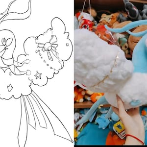 May include: A soft toy of a blue and white creature with long, flowing features. The toy has a light blue head and neck, with white fluffy wings and body. A gold star chain adorns the wing. The toy is held in front of a shelf filled with other soft toys.