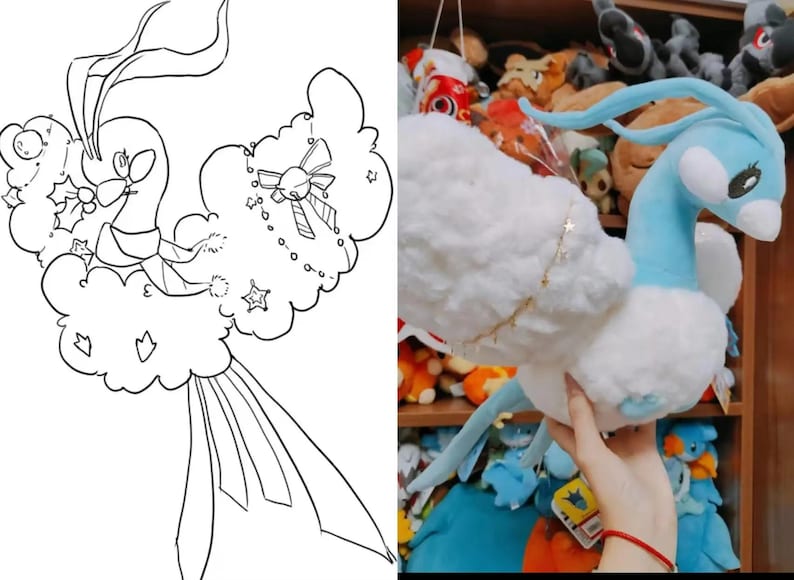 May include: A soft toy of a blue and white creature with long, flowing features. The toy has a light blue head and neck, with white fluffy wings and body. A gold star chain adorns the wing. The toy is held in front of a shelf filled with other soft toys.