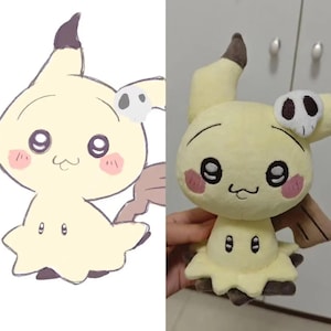 May include: A light yellow Mimikyu plush toy, featuring a black and white skull-shaped accessory. The toy has large black eyes, pink cheeks, and a small, smiling mouth. The design is based on the popular Pok&eacute;mon character.