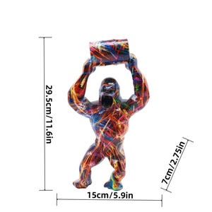 May include: A gorilla figurine with a multi-colored abstract paint splatter pattern, holding a rectangular object overhead. Dimensions are 11.6 inches in height, 5.9 inches in width, and 2.75 inches in depth as indicated by the text.