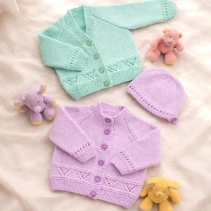 May include: Two baby sweaters, one mint green and one lavender, with matching hats. Each sweater has button closures and decorative cutouts. Small stuffed animal toys in pink, yellow, and purple are also present.