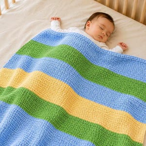 May include: A soft, textured baby blanket featuring horizontal stripes in alternating shades of light blue, grass green, and pale yellow. The blanket is draped over a sleeping infant who is wearing a plain white long-sleeved shirt.