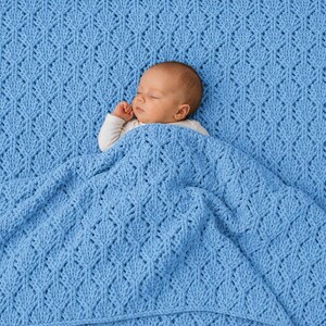 May include: A light blue knitted blanket featuring a repeating diamond-shaped textured pattern. The blanket is draped over a sleeping infant who is wearing a plain white long-sleeved shirt. The knit fabric has a consistent, soft, and uniform appearance.