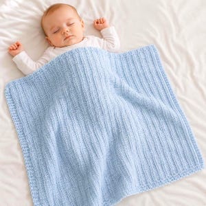 May include: A light blue knitted baby blanket with a vertical ribbed texture and a garter stitch border. The blanket is rectangular in shape and features a consistent knit pattern throughout, providing a soft and uniform appearance for a nursery.