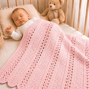 May include: A sleeping baby is nestled in a crib, covered by a soft, pink, crocheted blanket. The blanket features a scalloped edge and a repeating pattern of vertical stripes with openwork details. A teddy bear sits in the crib next to the baby.