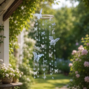 May include: A hanging mobile featuring a circular wooden frame with multiple strands of clear, translucent butterfly-shaped ornaments and spherical beads suspended from thin wires, creating a cascading arrangement of decorative elements.