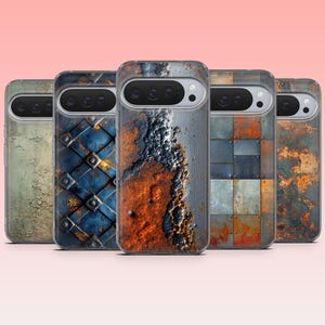 May include: A collection of five phone cases with unique, weathered metal textures. The designs include peeling paint, riveted blue metal, and rusted panels in shades of orange, gray, and blue. The cases are displayed against a soft pink background.