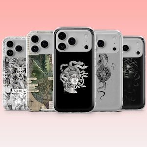 May include: A selection of phone cases showcasing Medusa artwork. The cases feature detailed black and white illustrations and graphic designs of Medusa. The cases are in clear protective covers, highlighting the artistic designs. The cases are in a row.
