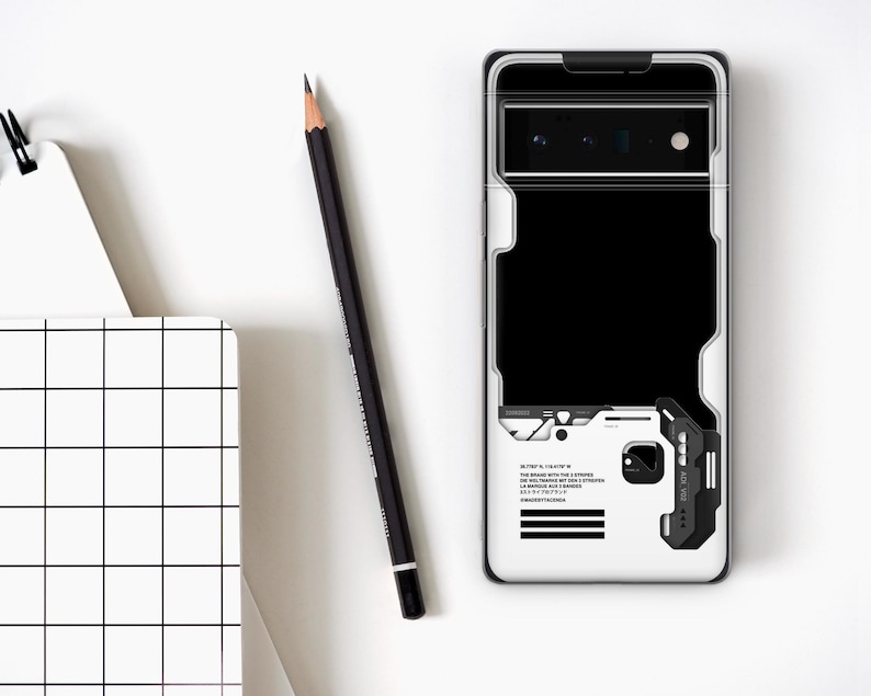 May include: A white phone case with a black and white geometric design, a black rectangle, and a black and gray accent. A black pencil and a white notebook with a grid pattern are also in the image.
