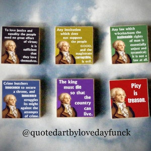 May include: Six colorful square wooden signs with quotes from Thomas Jefferson. Each sign features a portrait of Jefferson and a quote about justice, equality, government, and tyranny. The signs are arranged in two rows of three.